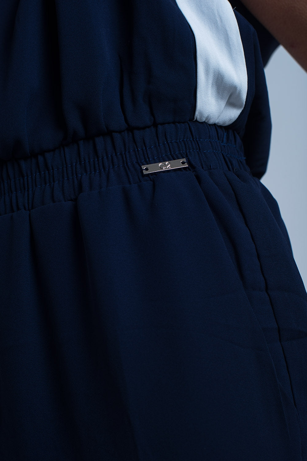 Navy blue jumpsuit with short sleeve and ruffle detail
