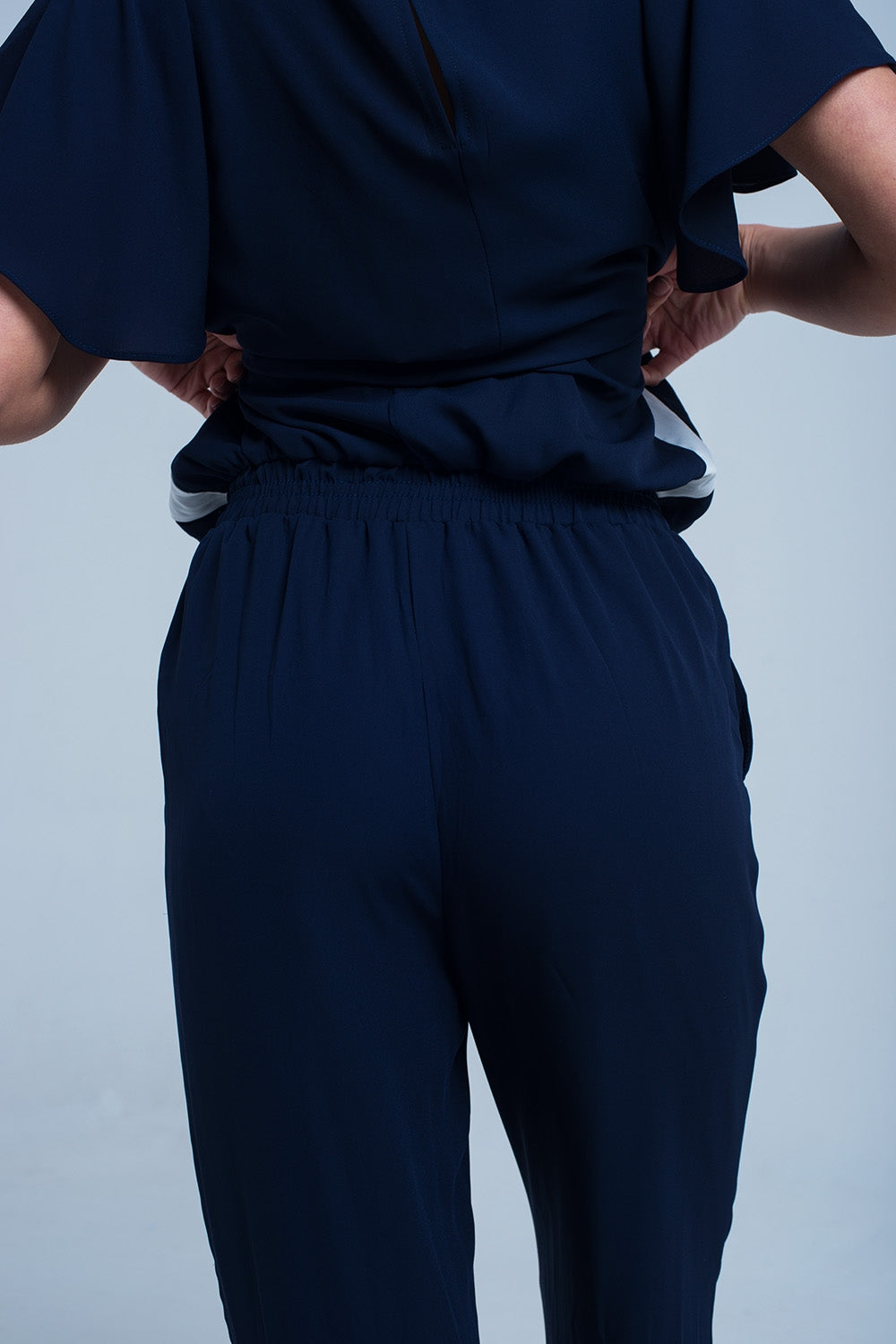 Navy blue jumpsuit with short sleeve and ruffle detail